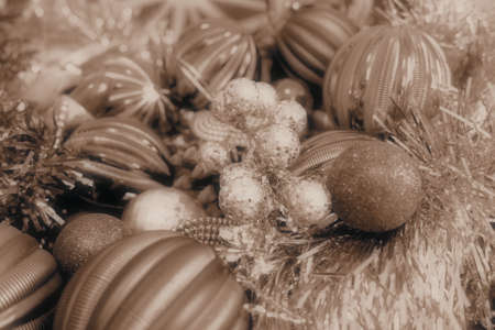 Christmas background with Christmas decorations, holiday balls, bells, bows, fir cone, Christmas tinsel. Happy New Year and Merry Christmas. Sepia monochrome retro vintage style. Postcard or backdrop.の写真素材