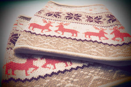 Scarf collar or scarf - snood. Jacquard knitted pattern. Geometric ornament for Christmas or New Year. Red deer on white knitted background. Winter fashionable modern animal traditional folk ornament.の写真素材