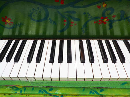 Octaves, white and black keys on a piano or grand piano. Green deck. Musical theme. Keyboard stringed musical instrument with percussion hammer method of sound production.の写真素材