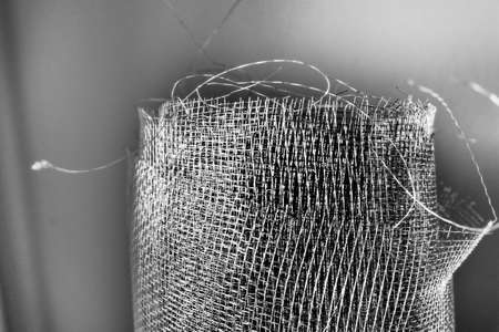Metal mesh. Rolled mesh in gray. Heavy duty steel or aluminum mesh with ragged edgesの写真素材