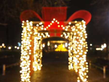 Bokeh on Christmas night. Beautiful round bokeh highlights. Red, yellow, gold, white colors in the dark. Festive background for New Year Merry Christmas. Blurred defocus. Decoration of city streetsの写真素材