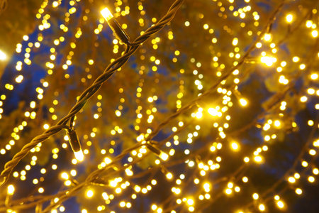 bokeh highlights. Golden and yellow color flashes in the dark. Festive background. Blurred defocus....