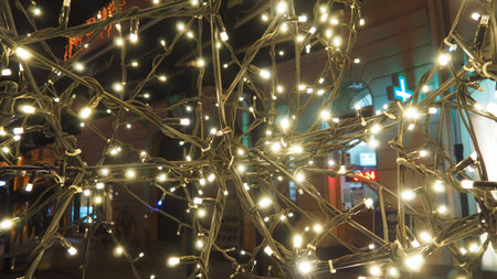 Street garlands with white small lamps in the evening on a city street. Festive new year christmas...