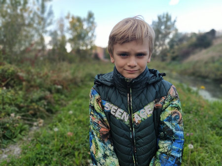Sremska Mitrovica Serbia October 20 2021. A handsome blond boy of 8 years old in a green jacket...