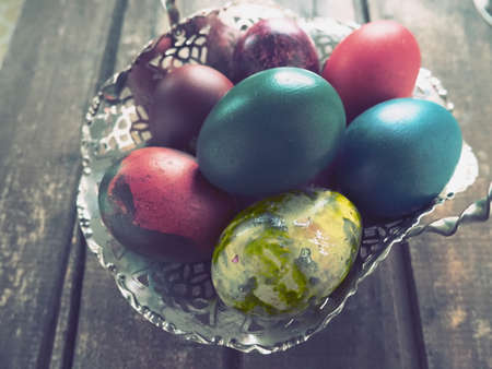 Easter colored eggs in an old metal candy bowl on a wooden table. Easter, the Resurrection of Christ, the Bright Resurrection of Christ, the most ancient and Christian holiday.の写真素材