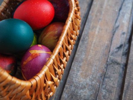 Happy Easter. Easter colored eggs in a wicker basket on a wooden table. Easter, the Resurrection of Christ, the Bright Resurrection of Christ, the most ancient and Christian holidayの写真素材