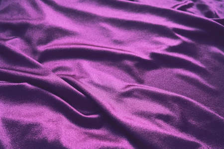 Velour fabric, similar to silk. Textiles in a folds and beautiful waves. Purple, pink, magenta shades on the drapery. Sewing material for evening dresses, furniture upholstery, curtains and interior.の写真素材