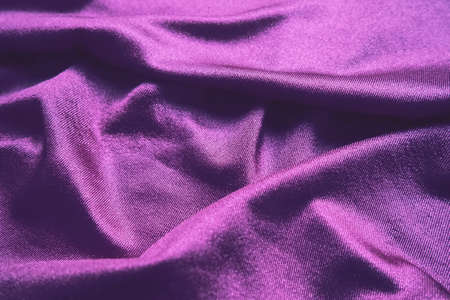 Velor fabric, similar to silk. Textiles in a folds and beautiful waves. Purple, pink, magenta shades on the drapery. Sewing material for evening dresses, furniture upholstery, curtains and interiorの写真素材