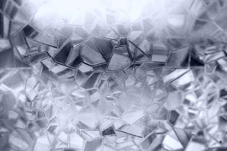 Embossed glass background. Corrugated glass monochrome. Refraction of light in a bumpy transparent surface under backlight. The play of white and gray highlights. Black areas. Abstract background.の写真素材