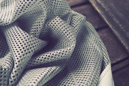 Synthetic fabric with holes laid in waves. Beautiful drape. Fabric for curtains, interior design,...