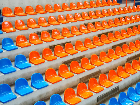 Bleachers, empty seats in the stands of the arena or auditorium. Rows of blue and orange stadium seats without spectators. The concept of the abolition of sports and mass entertainment eventsの写真素材