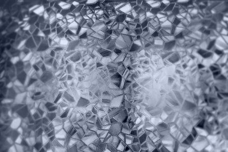 Embossed glass background. Corrugated glass monochrome. Refraction of light in a bumpy transparent surface under backlight. The play of white and gray highlights. Black areas. Abstract background.の写真素材