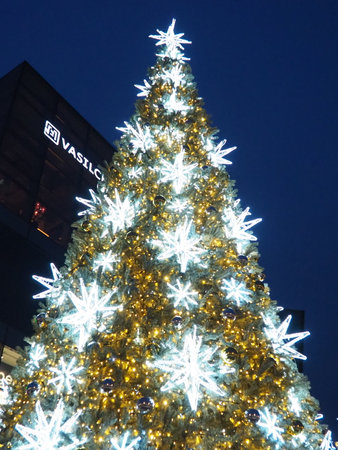 Moscow, Russia, January 17 2023 Street Christmas tree with snowflakes and festive balls. Metro Yugo-Zapadnaya. Christmas decorations in front of the mall. Silver stars, snowflakes and golden garlands.のeditorial素材