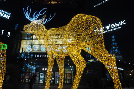 Moscow, Russia, January 17 2023 Metro Yugo-Zapadnaya. Christmas decorations in front of the mall. New year street decorations in the form of sparkling deer. Deer figure made from yellow gold garlands.のeditorial素材