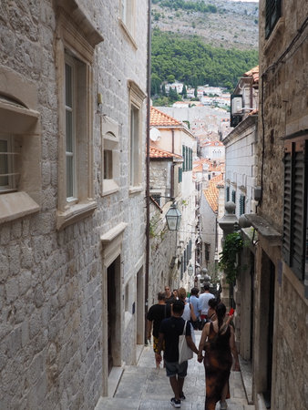 Dubrovnik, Croatia, 08.14. 2022. Narrow streets of the ancient town. The facades of the houses are made of marble and stone very close to each other. Windows with shutters. Summer tourism in Adriatic.のeditorial素材