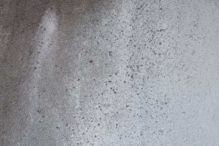 Plastered wall texture. Whitewash surface. Abstract background. Retro wall built structure texture. Cracks and bumps on the concrete wall. Uneven coloring with water-based paint. Old tattered plasterの写真素材