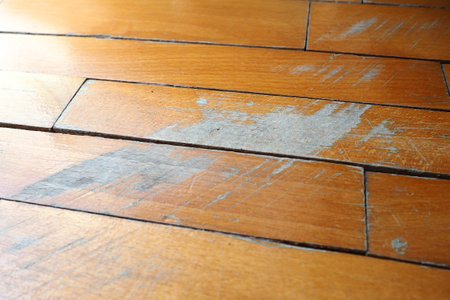 Old, scratched parquet flooring needs maintenance. The parquet is damaged by scratches from prolonged useの写真素材