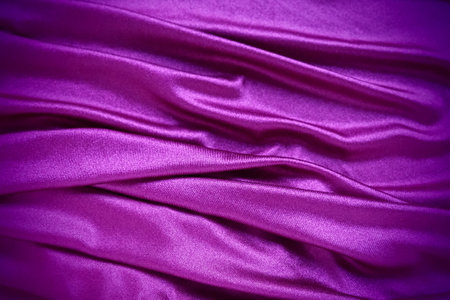 Velour fabric, similar to silk. Textiles in a folds and beautiful waves. Purple, pink, magenta shades on the drapery. Sewing material for evening dresses, furniture upholstery, curtains and interior.の写真素材