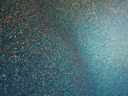 Deep blue. Texture of rough paper or cardboard. Defocused bokeh sparkles and shining. Festive blue background with illuminated sapphire gradientの写真素材