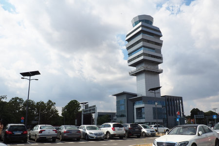 Belgrade, Serbia 09.17.23 Nikola Tesla International Airport in Surcin. New airport buildings. Increase in passenger traffic flying by plane. Cars, people, bus station, parking. Tower with antennasのeditorial素材