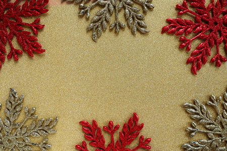 Six large silver and red flat ornate snowflakes are laid out on velvety gold paper. Free space for text. New Year or Christmas background for advertising. Festive winter flatlay. Yellow red gray colorの写真素材