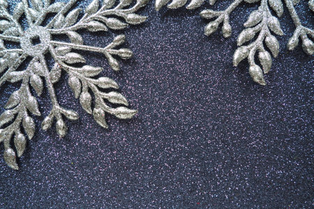 Two large silver flat ornate snowflakes are laid out on velvety black paper. Free space for text. New Year or Christmas background for advertising. Festive winter flat lay. Beautiful snowflake.の写真素材