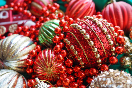 New Years Christmas balls, tinsel and decorations close up. A lot of decoration of golden, red, yellow, green. Striped Christmas balls. Festive beautiful colorful background. Home holidays design.の写真素材