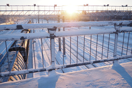 Railway station. Passenger freight trains on rails. Winter short polar day. Snow and snowdrifts.の写真素材