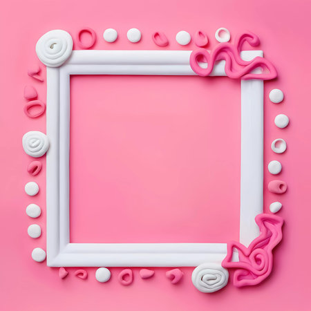 A rectangular frame crafted from white and pink play dough features intricate designs around an empty center. This artistic setup invites creativity and imagination.の素材