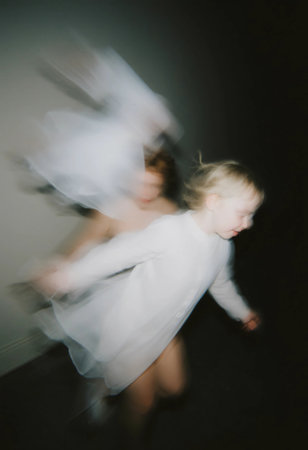 Ethereal figures glide through the darkness as a child joyfully runs, creating an enchanting scene filled with playful spirits and mystery at night.の素材