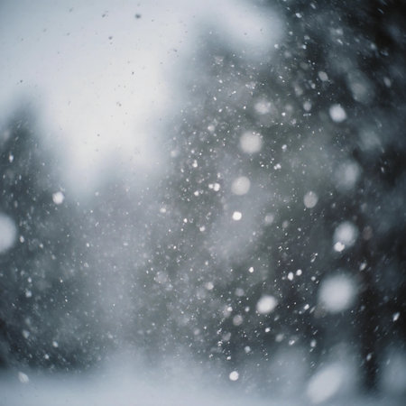 White snowflakes fall from the sky and gather on the ground. Trees stand behind a curtain of snow, creating a winter landscape on a cold day.の素材