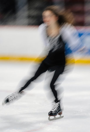 A figure skater practices movements on ice during the winter season. The atmosphere hints at festive celebrations for Christmas and New Year.の素材