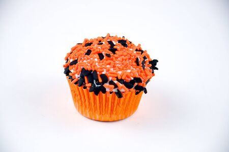 A Chocolate Cupcake with Halloween Sprinkles in a orange foil wrapperの写真素材