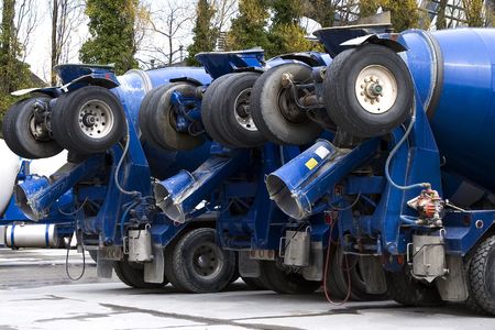 A row of blue cement trucks with their back wheels up. の写真素材