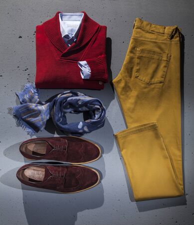 Quality stylish men's clothes and accessories. Folded men's shirt and sweater, shoe, blue scarf and pants isolated.の写真素材