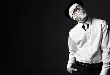 Strange, injured man in white shirt and black pants, wearing stylish hat and glasses. His head...