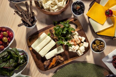 top view of a delicious breakfast with eggs, american /swiss cheese, olives, tomato, tea, parsley, cucumber on wooden backgroundの写真素材