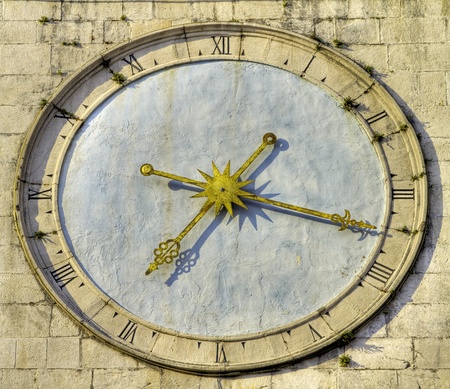 Ancient clock with roman numbers and golden hands.の写真素材