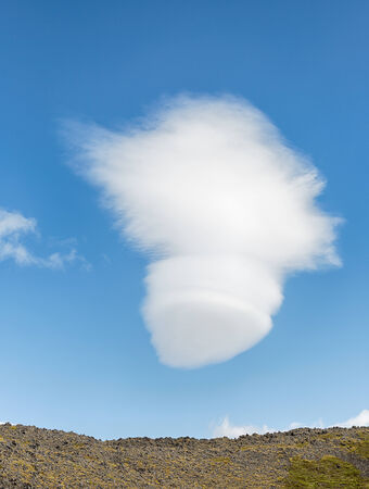 White fluffy cloud floating on a clear blue sky の写真素材