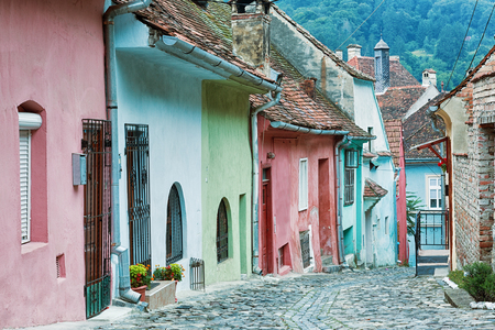 Old street with pastel coloured houses in Sighisoara, Romania.の写真素材
