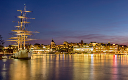 Vintage ship and city lights at night.の写真素材