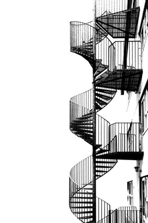 Metal spiral staircase for fire escape, black and white image.