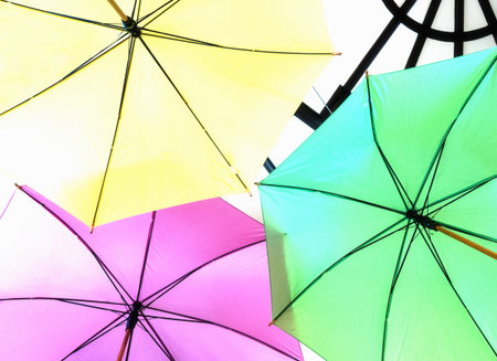 Pink, yellow and green umbrellas. High key image.