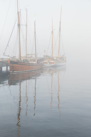 Wooden vintage ships on a foggy morning.