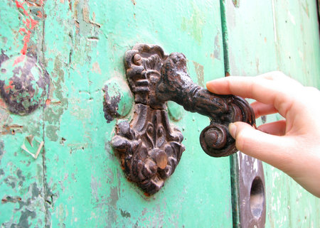 A woman knocking on the door of a house