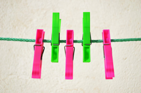 Colorful clothes pegs on line pink and green