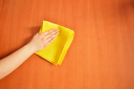 woman cleaning furniture  with yellow clothの写真素材