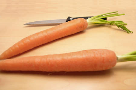 two carrots and a knife on a tableの写真素材