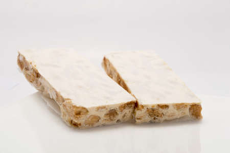 Pieces of Christmas hard almond turron on white plateの写真素材