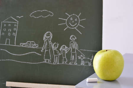 blackboard with a drawing of a boy and an apple to eatの写真素材